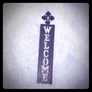 Metal welcome sign with cross